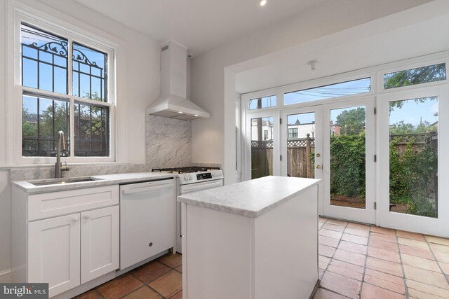 108 3rd St NE, Washington, DC 20002 - kitchen with wall chimney range hood, dishwasher, white cabinets, a kitchen island, and decorative backsplash