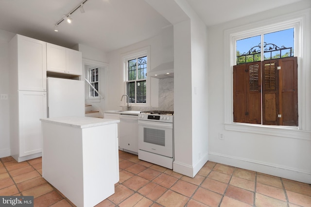 108 3rd St NE, Washington, DC 20002 - kitchen featuring white appliances, track lighting, white cabinets, light countertops, and a kitchen island