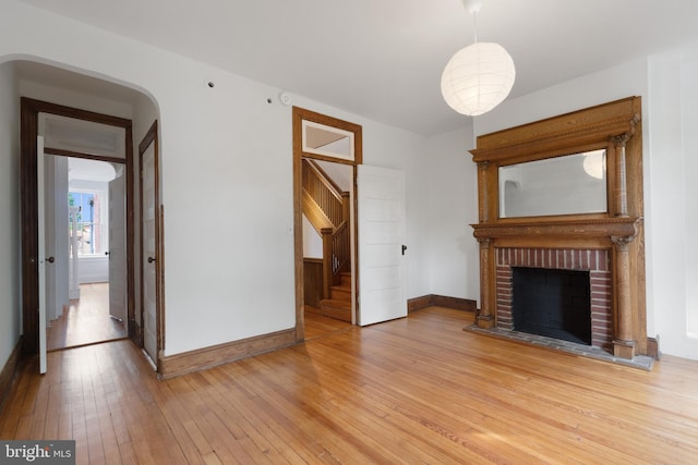 108 3rd St NE, Washington, DC 20002 - unfurnished living room featuring light wood-style floors, stairway, and a brick fireplace