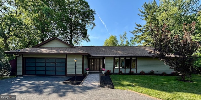 single story home with an attached garage, driveway, and a front lawn