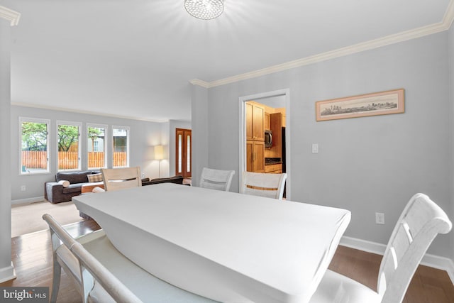 dining area with crown molding, baseboards, and dark wood-type flooring