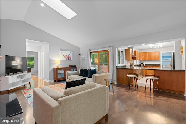 living area with vaulted ceiling, wood finished floors, and a skylight