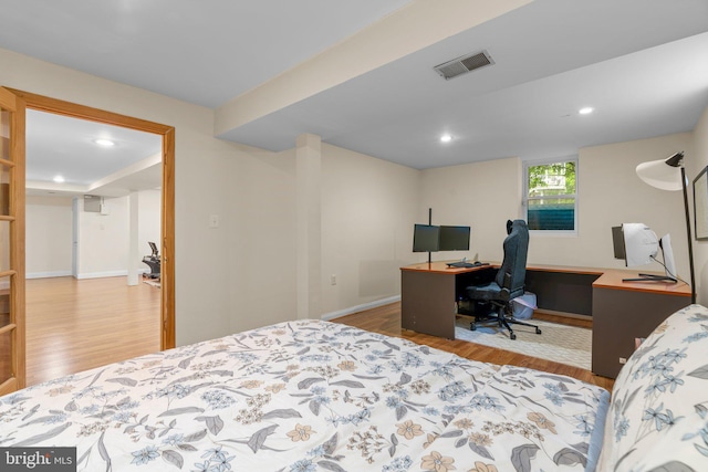 bedroom featuring wood finished floors, an office area, recessed lighting, and baseboards