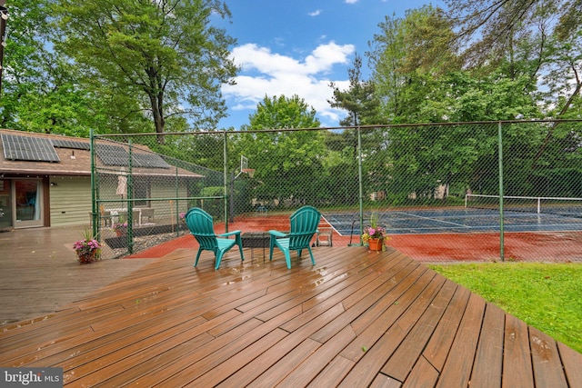 deck featuring a tennis court and fence