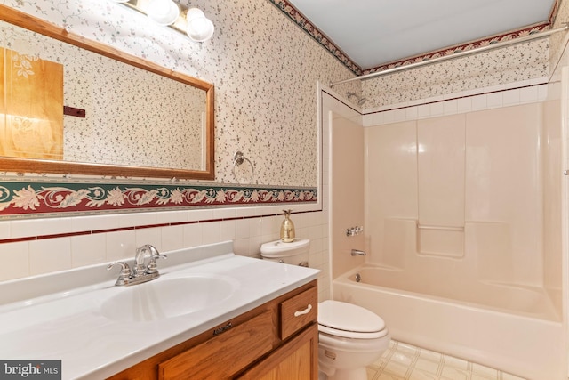 full bath with wallpapered walls, toilet, shower / tub combination, vanity, and a wainscoted wall