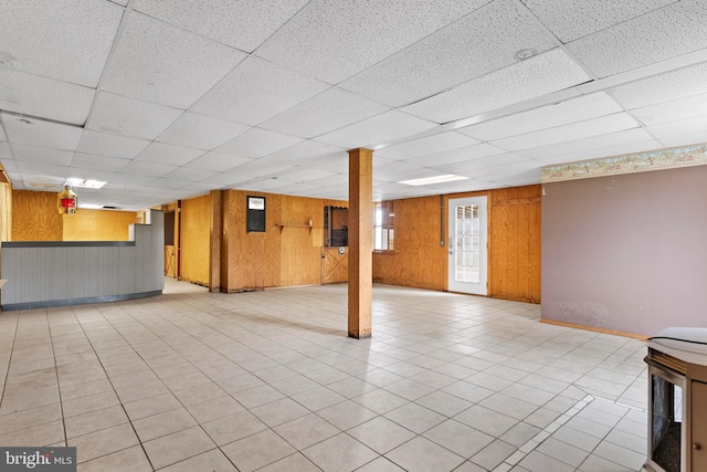 below grade area featuring a paneled ceiling and wood walls