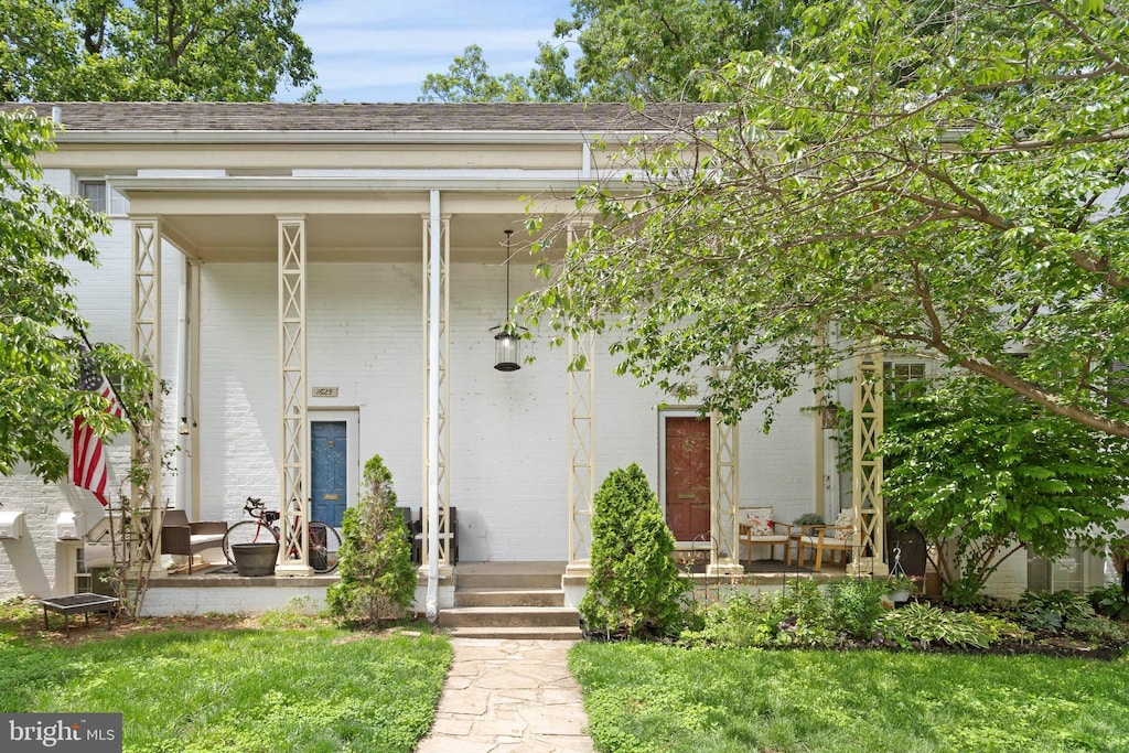 1623 Ripon Pl, Alexandria, VA 22302 - view of exterior entry featuring covered porch, brick siding, a lawn, and roof with shingles