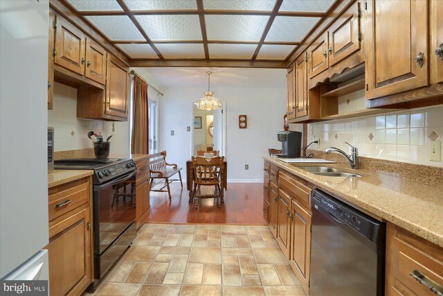 438 N 4th St, Halifax, PA 17032 - kitchen with black appliances, tasteful backsplash, brown cabinetry, and a chandelier