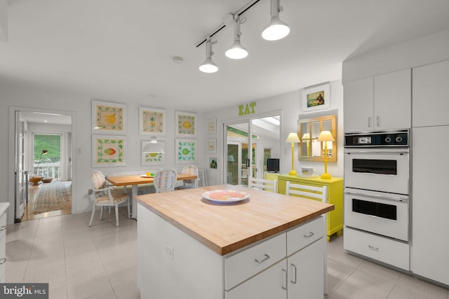 17810 Pond Rd, Ashton, MD 20861 - kitchen featuring butcher block counters, white double oven, white cabinets, and a kitchen island