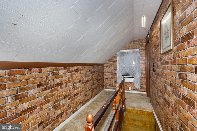 6109 Oakland Mills Rd, Sykesville, MD 21784 - hall with vaulted ceiling, brick wall, and dark colored carpet