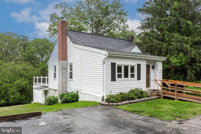 6109 Oakland Mills Rd, Sykesville, MD 21784 - bungalow-style house with a chimney, roof with shingles, a front lawn, and a wooden deck