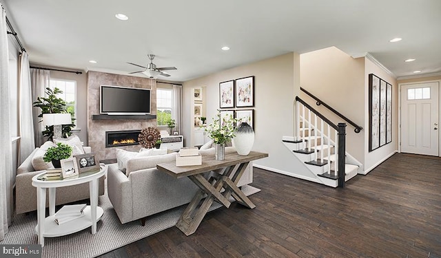 living room with dark wood-style floors, healthy amount of natural light, a fireplace, recessed lighting, and crown molding