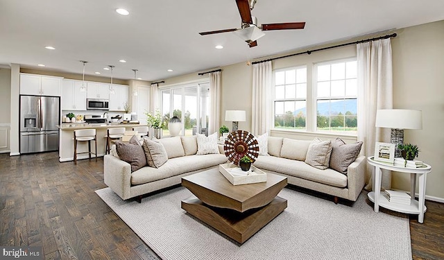 living area featuring a ceiling fan, recessed lighting, and dark wood finished floors