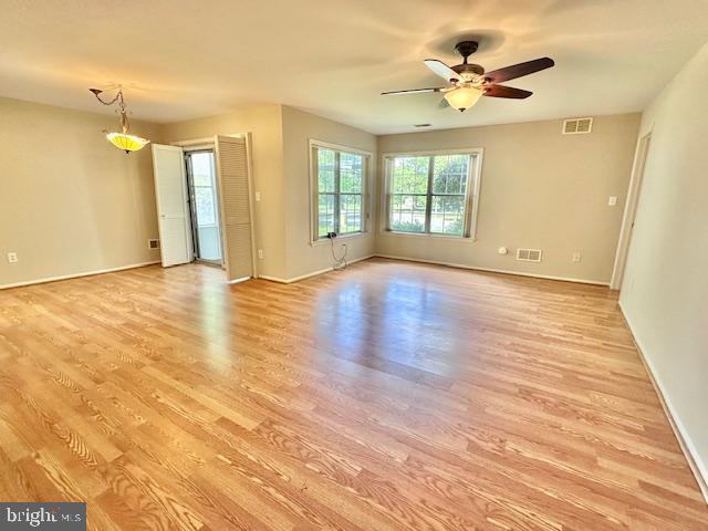 empty room with light wood-type flooring, baseboards, and a ceiling fan