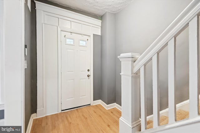 1081 Ellicott Dr, Baltimore, MD 21216 - foyer entrance with light wood-style flooring, baseboards, and stairs