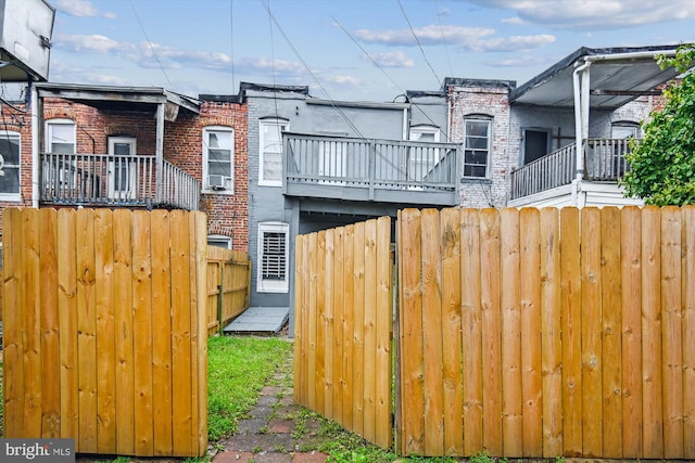 1081 Ellicott Dr, Baltimore, MD 21216 - view of side of property with fence, brick siding, and a balcony