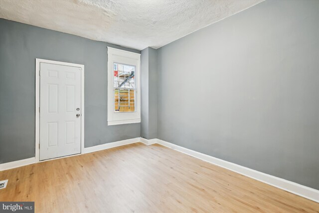 1081 Ellicott Dr, Baltimore, MD 21216 - spare room with wood finished floors, a textured ceiling, and baseboards