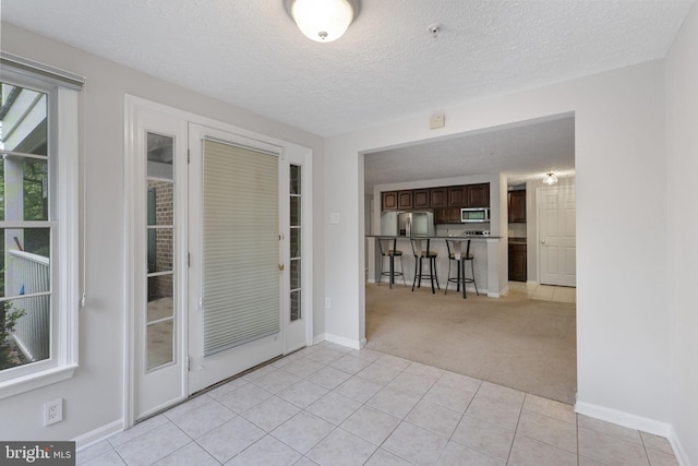 13113 Briarcliff Ter Unit 1-101, Germantown, MD 20874 - interior space with light colored carpet, baseboards, light tile patterned flooring, and a textured ceiling