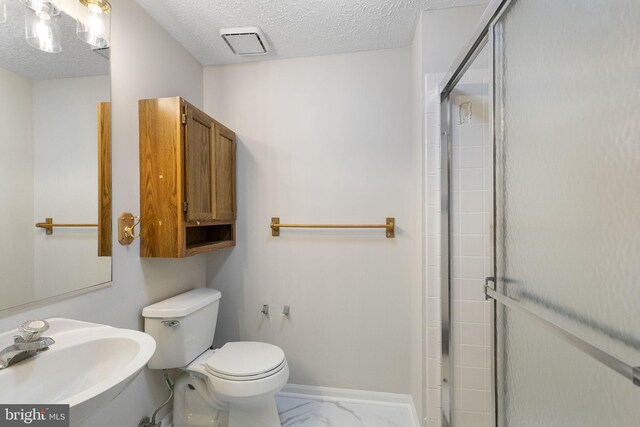 13113 Briarcliff Ter Unit 1-101, Germantown, MD 20874 - bathroom featuring a sink, a shower stall, toilet, marble finish flooring, and a textured ceiling