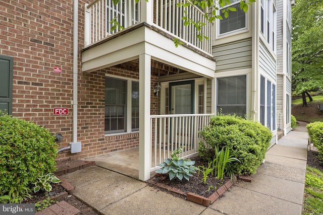 13113 Briarcliff Ter Unit 1-101, Germantown, MD 20874 - view of exterior entry with a balcony, brick siding, and covered porch