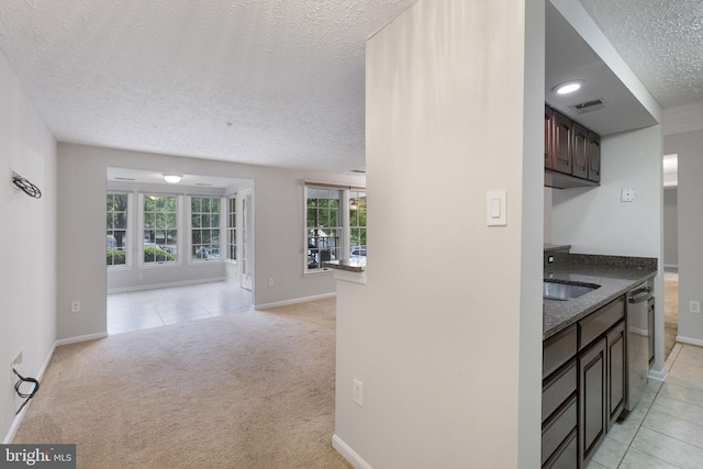 13113 Briarcliff Ter Unit 1-101, Germantown, MD 20874 - kitchen featuring a textured ceiling, stainless steel dishwasher, a sink, baseboards, and open floor plan