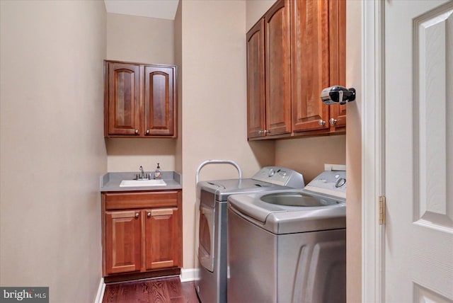 clothes washing area with cabinet space, separate washer and dryer, dark wood-type flooring, and baseboards
