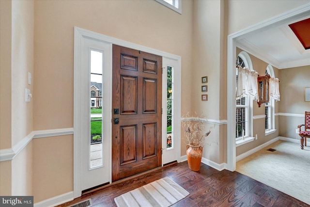 entrance foyer with dark wood-type flooring, baseboards, and ornamental molding