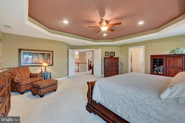 carpeted bedroom with a raised ceiling, baseboards, recessed lighting, and a ceiling fan