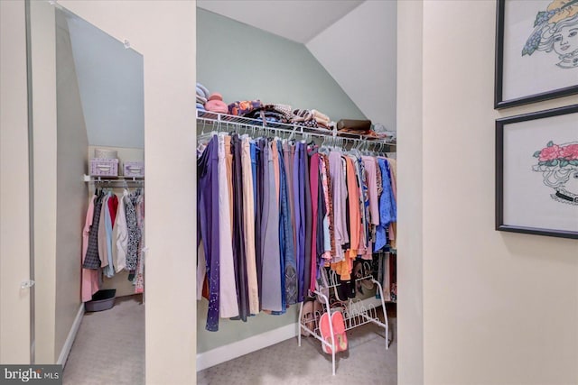 spacious closet featuring vaulted ceiling and carpet flooring
