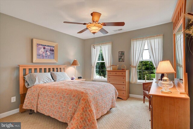 bedroom featuring light carpet, baseboards, and ceiling fan