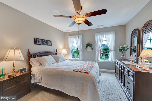 bedroom with light colored carpet, baseboards, and a ceiling fan