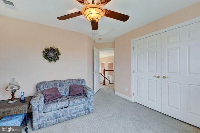 sitting room with a ceiling fan, carpet flooring, attic access, an upstairs landing, and baseboards