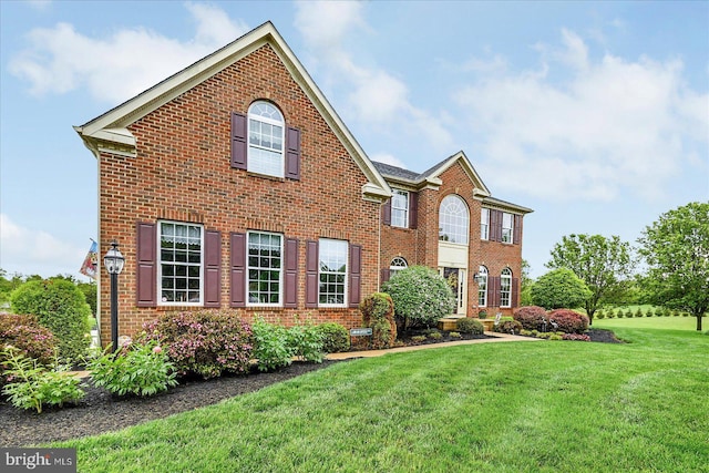 view of front of home featuring brick siding and a front yard