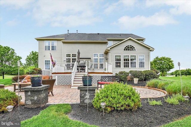 back of property featuring a patio and a deck