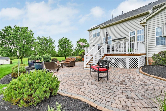 view of patio with a wooden deck, an outdoor hangout area, and stairs