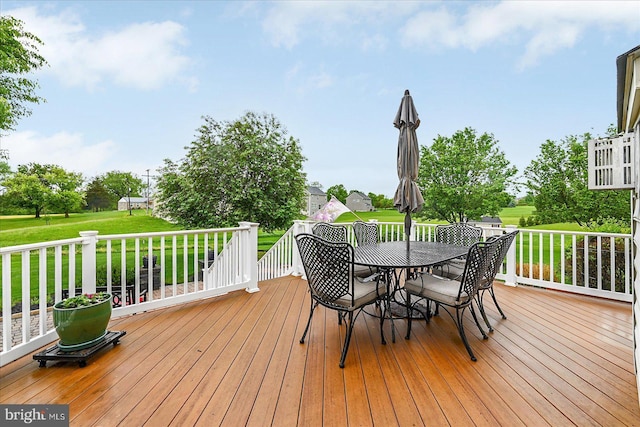 wooden deck with a lawn and outdoor dining space