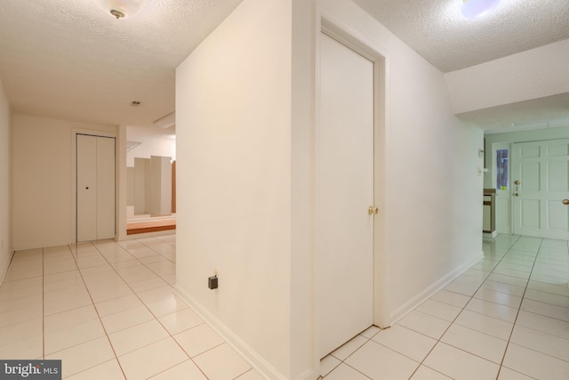 4001 Cedar Mills Rd, Randallstown, MD 21133 - corridor featuring a textured ceiling, light tile patterned floors, and baseboards