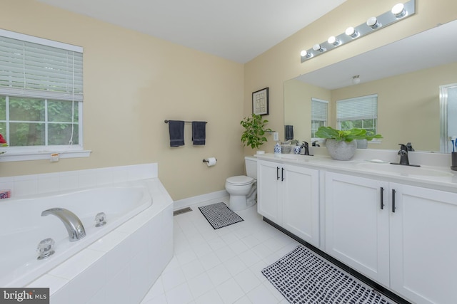 bathroom featuring a bath, double vanity, toilet, and healthy amount of natural light