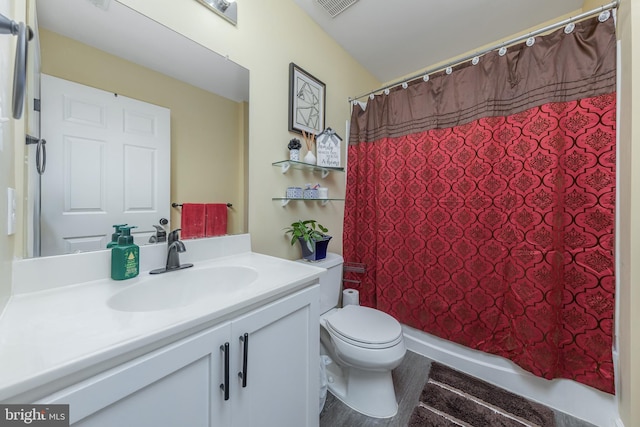 full bathroom with toilet, vanity, and curtained shower