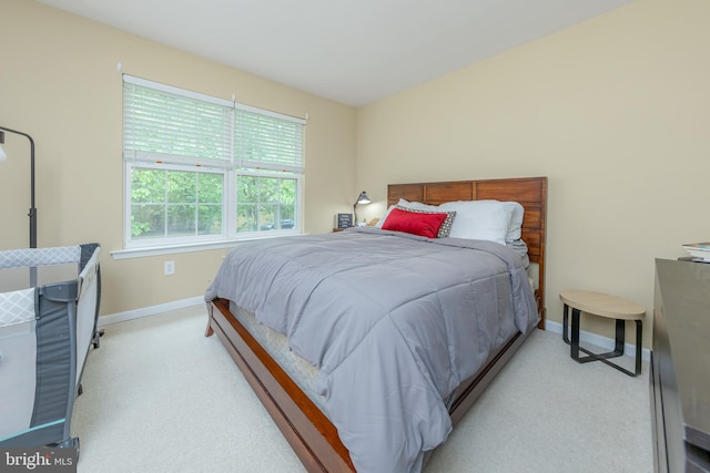 bedroom featuring light carpet and baseboards