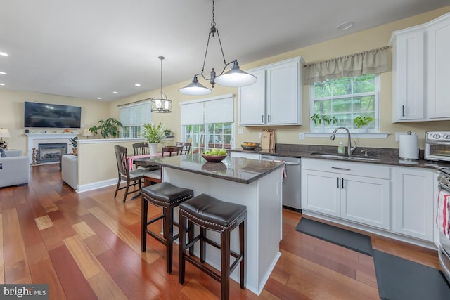 kitchen with a sink, stainless steel dishwasher, plenty of natural light, a kitchen island, and recessed lighting