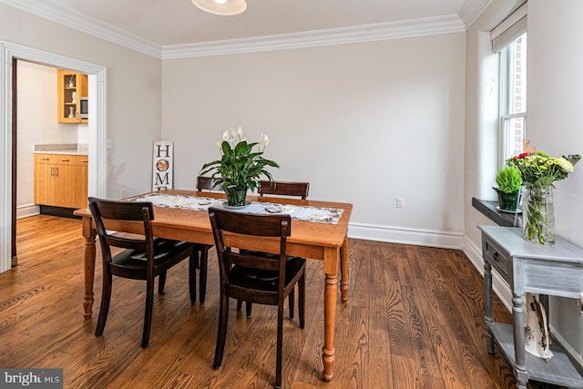 dining area featuring ornamental molding, baseboards, and wood finished floors