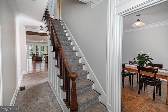 stairway with ornamental molding, french doors, baseboards, and wood finished floors