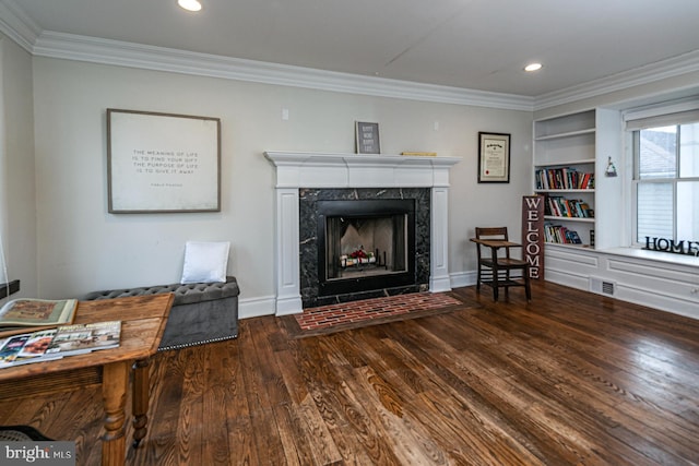 living area with ornamental molding, wood finished floors, a high end fireplace, baseboards, and recessed lighting