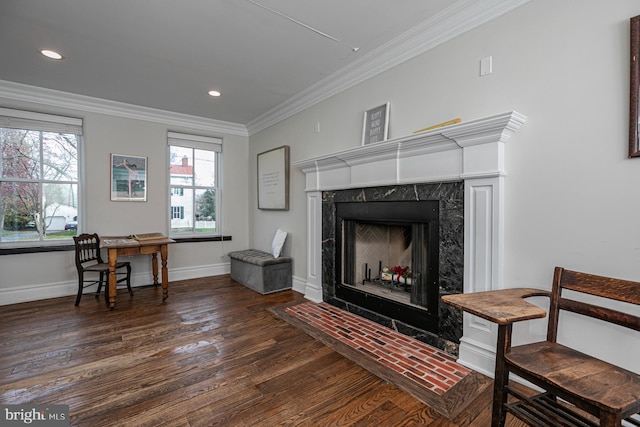 living area with wood finished floors, a fireplace, crown molding, baseboards, and recessed lighting