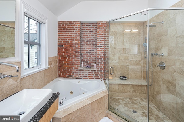bathroom with healthy amount of natural light, a whirlpool tub, a shower stall, lofted ceiling, and a sink