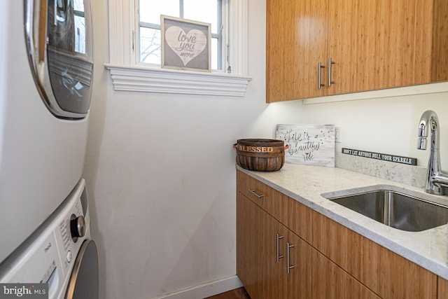 laundry area with estacked washer and dryer, cabinet space, and baseboards