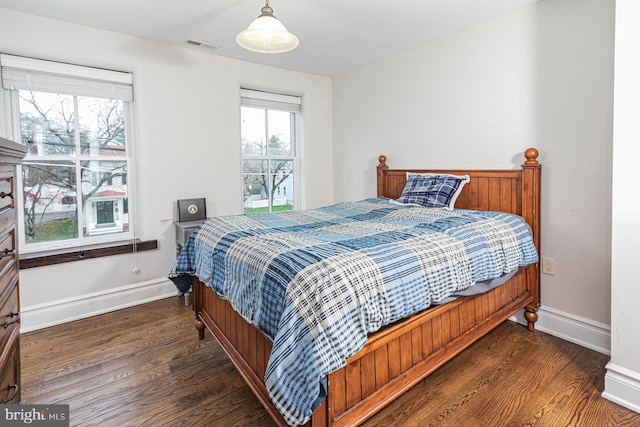 bedroom with wood finished floors and baseboards
