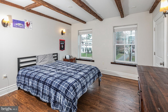 bedroom with baseboards, beamed ceiling, and wood finished floors