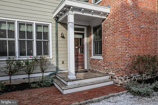 property entrance featuring brick siding